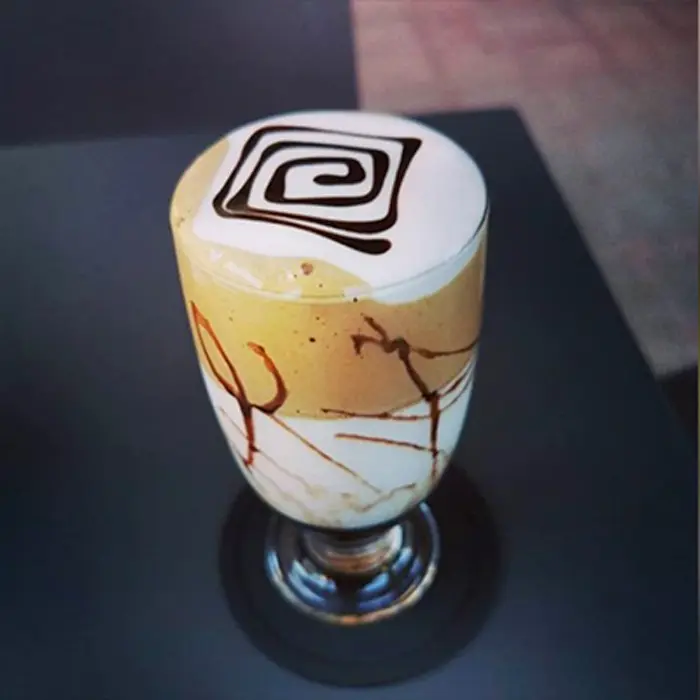 Caffe freddo decorato con crema e cioccolato